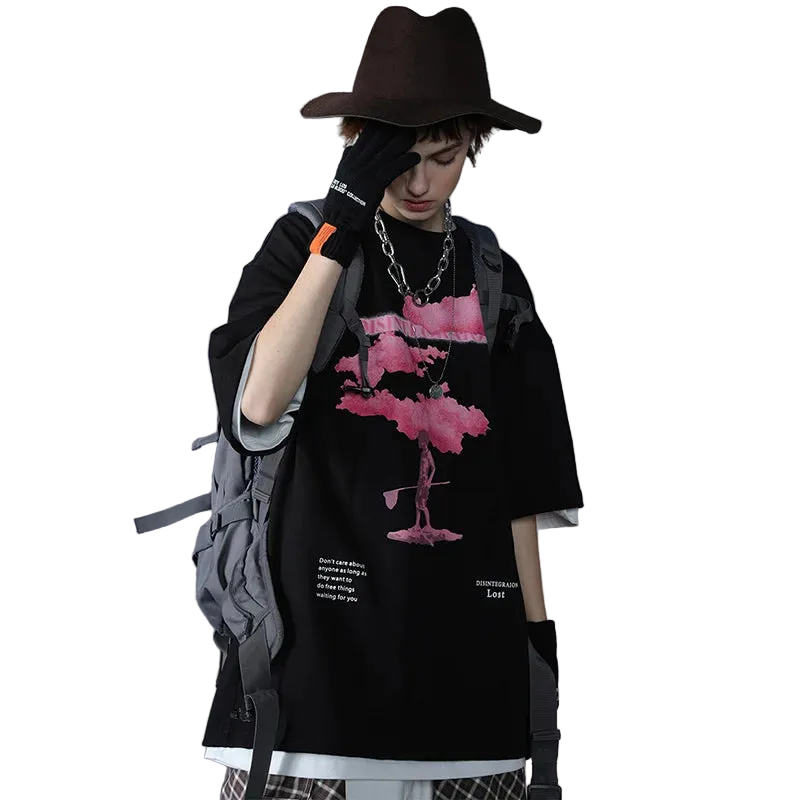 Person wearing a black outfit with a pink flamingo design, holding a phone, on a gray background