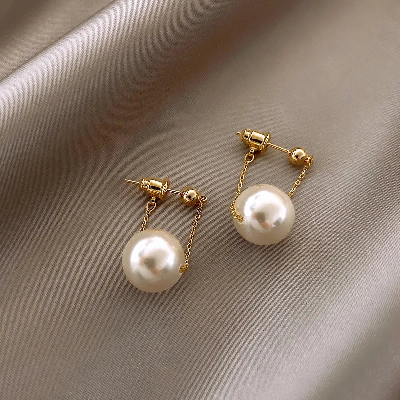 Boucles d'oreilles pendantes élégantes avec petit pendentif en perle