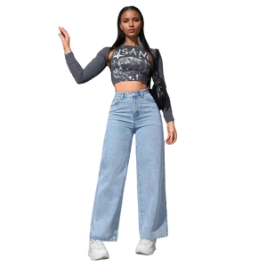 Woman wearing a crop top and high-waisted jeans against a gray wall.