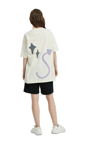 Person wearing a white oversized t-shirt with colorful designs on a plain background