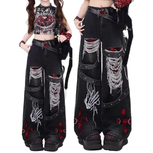 Black distressed jeans with red and white designs worn by a model on a white background