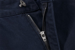 Close-up of a navy blue jacket with a zipper and button detail.