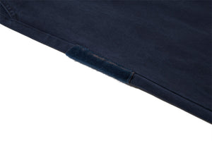 Close-up of a dark blue denim fabric corner on a white background