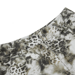 Close-up of a camouflage-patterned shirt with a leopard print detail on a white background