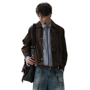 Man wearing a brown jacket with a checkered shirt and jeans, holding a black bag.