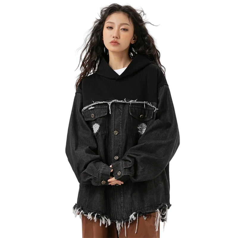 Person wearing a black distressed denim jacket on a white background