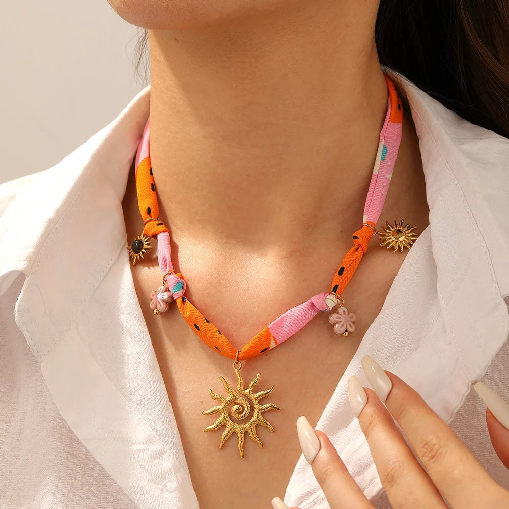 Collier en céramique avec motif de fleur et totem du soleil doré