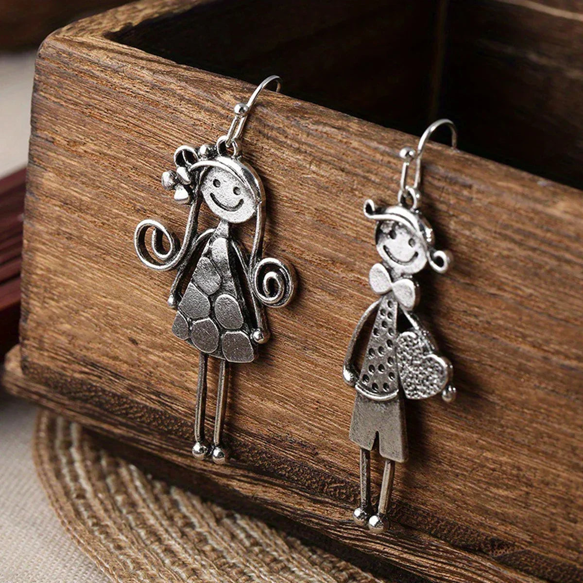 Boucles d'oreilles pendantes en métal style rétro minimaliste, représentant un couple, avec des personnages.
