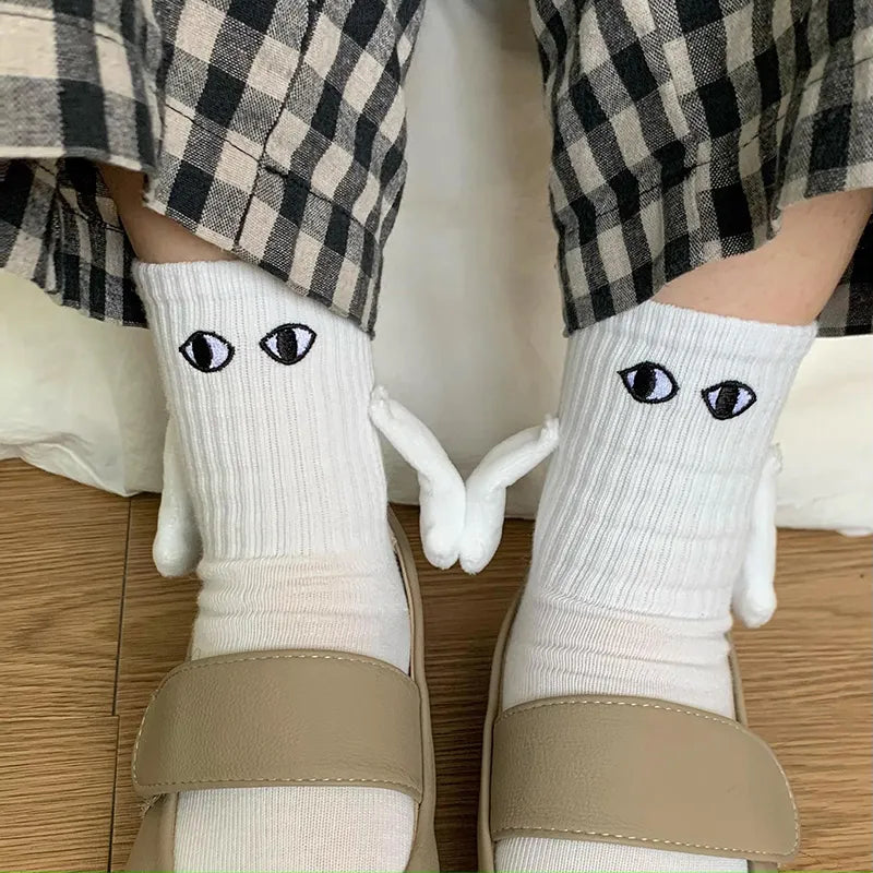 Socken mit magnetischen Händen und Cartoon-Augen
