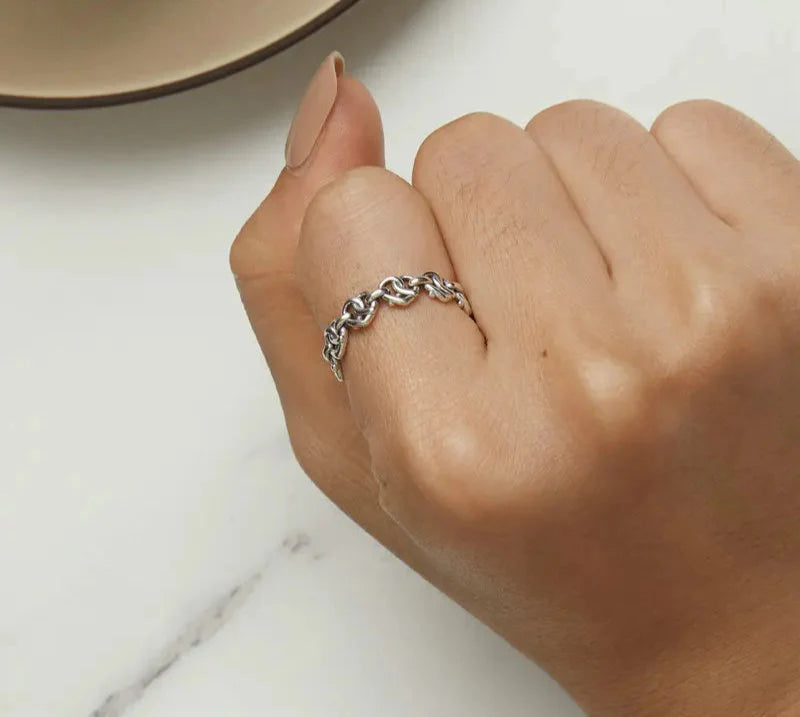 Platinring mit verschränkter Herzkette