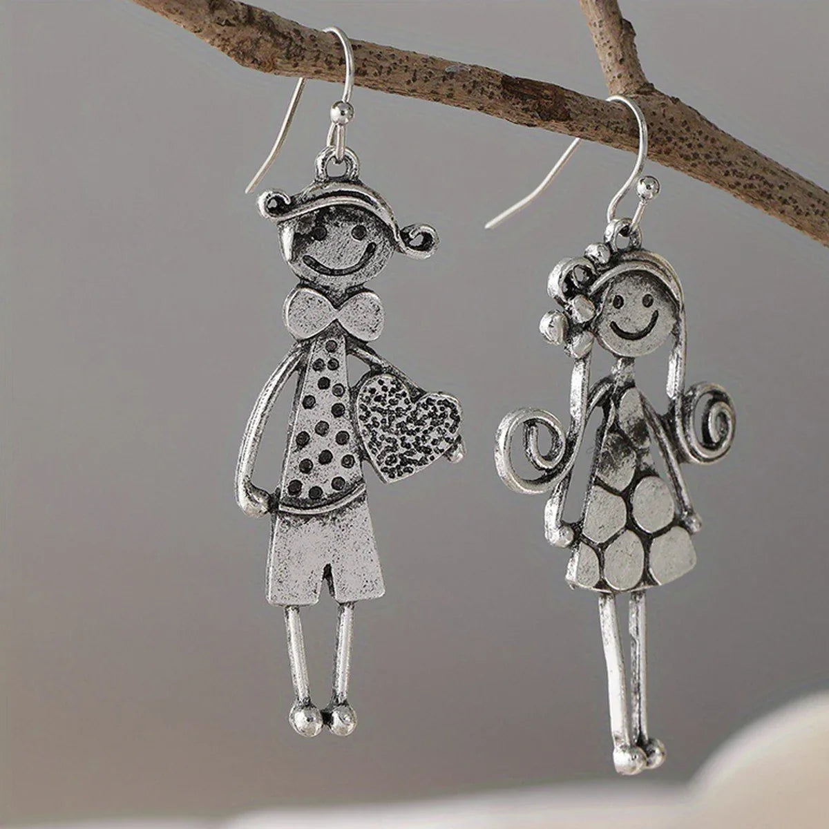 Boucles d'oreilles pendantes en métal style rétro minimaliste, représentant un couple, avec des personnages.