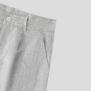 Close-up of gray pants with a button on a light gray background