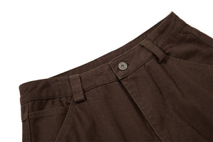 Close-up of brown pants with a button on a white background