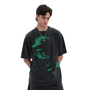 Person wearing a black t-shirt with a green graphic design on a white background