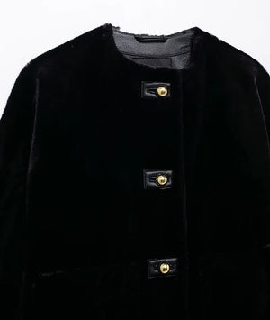 Close-up of a black coat with gold buttons on a white background