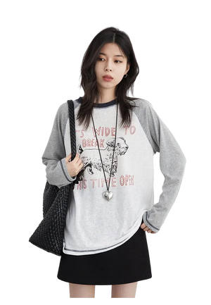 Woman wearing a gray and white long-sleeve shirt with text and a black skirt on a white background