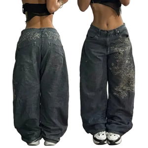Two views of dark blue jeans with embroidery on a plain background