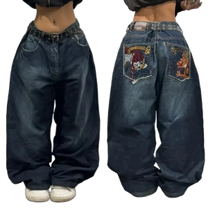 Blue jeans with embroidered designs on the back pocket worn by a person.