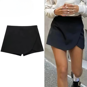 Black mini skirt shown on a plain background and worn by a person outdoors.