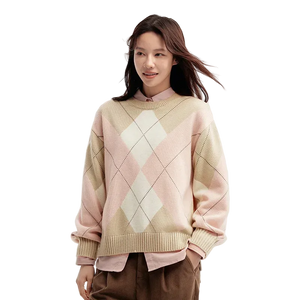 Woman wearing a pastel argyle sweater on a light background