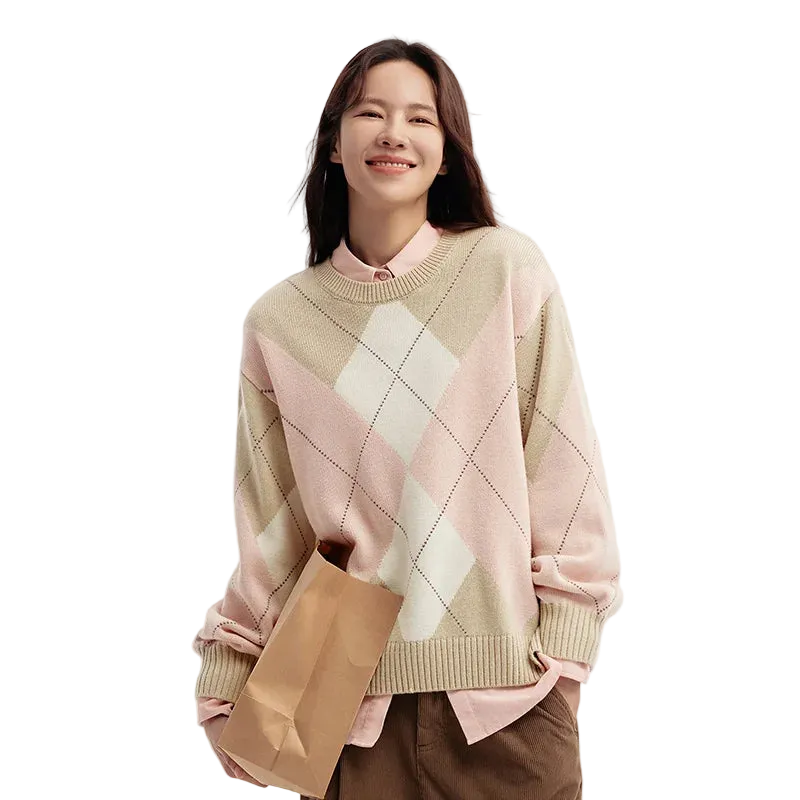 Woman wearing a pink and beige argyle sweater holding a brown paper bag on a white background