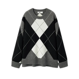 Black, gray, and white argyle sweater on a white background