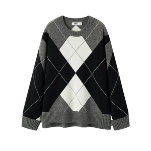 Black, gray, and white argyle sweater on a white background