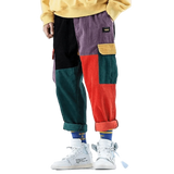 Colorful patchwork pants worn by a person on a plain background