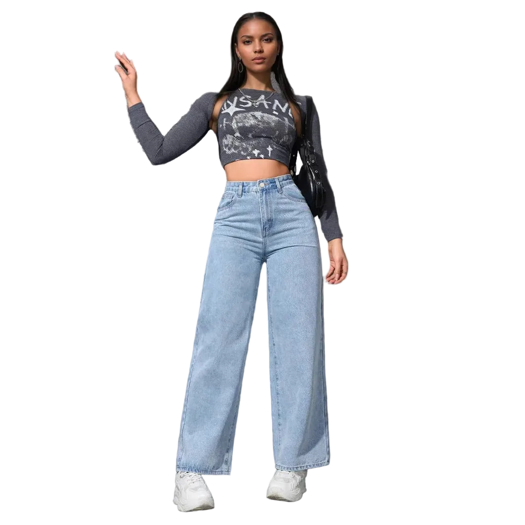 Woman wearing a crop top and high-waisted jeans against a gray wall.