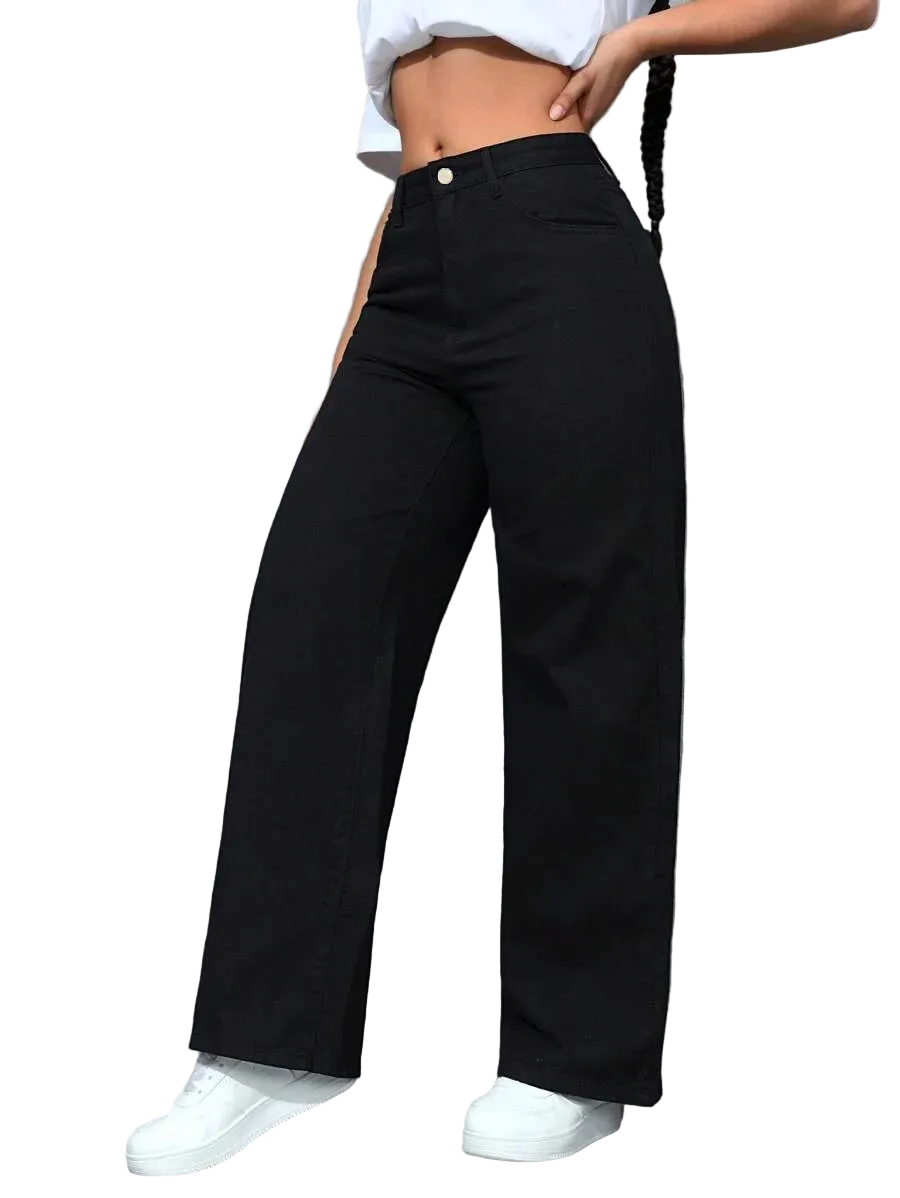 Person wearing black wide-leg pants and white sneakers against a gray wall.