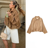 Effortlessly chic and oversized black bomber jacket with sophisticated collar and epaulet details.