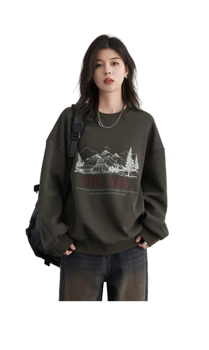 Person wearing a dark green sweatshirt with a graphic design on a plain background