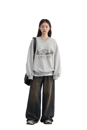 Person wearing a gray sweatshirt with text and graphics, standing against a white background