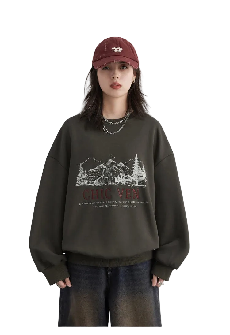 Person wearing a dark green sweatshirt with a graphic design and text, paired with a red cap on a light gray background.