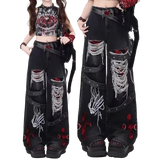 Black distressed jeans with red and white designs worn by a model on a white background