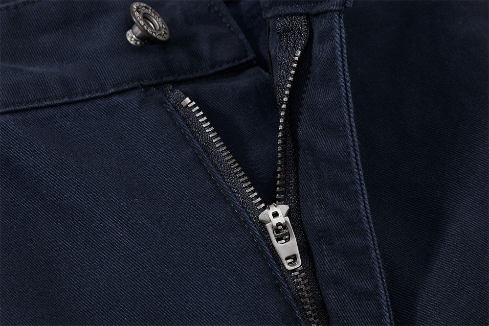 Close-up of a navy blue jacket with a zipper and button detail.