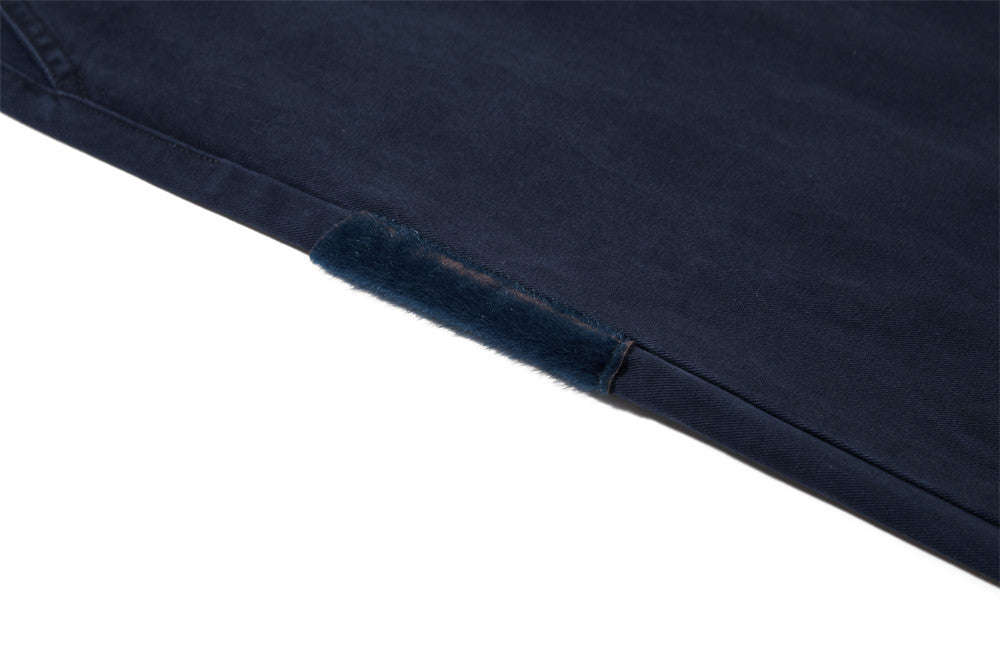 Close-up of a dark blue denim fabric corner on a white background