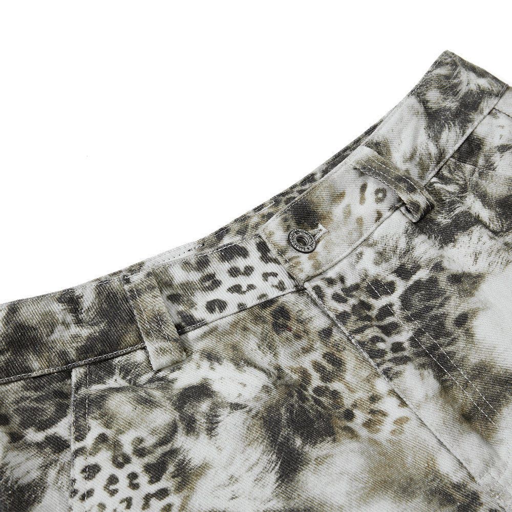 Close-up of a camouflage-patterned shirt with a leopard print detail on a white background