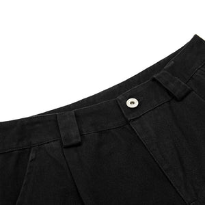 Close-up of black pants with a button on a white background