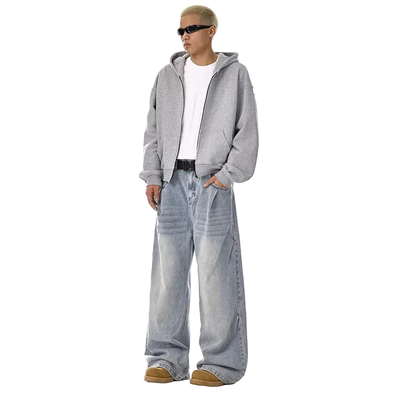 Person wearing a gray hoodie and light blue jeans on a white background