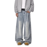 Person wearing a gray jacket and light blue jeans on a white background