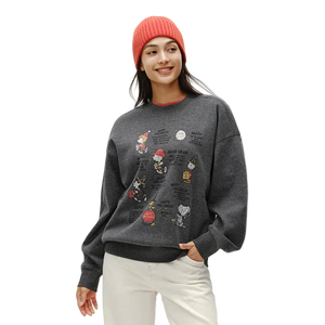 Person wearing a dark gray sweatshirt with colorful graphics and a red beanie on a white background