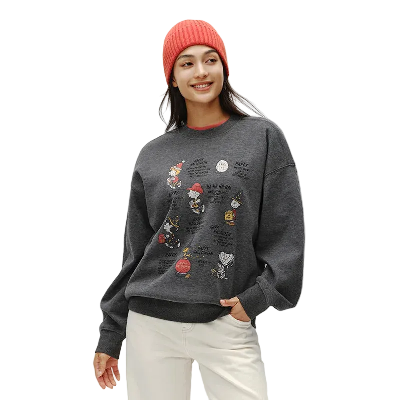 Person wearing a dark gray sweatshirt with colorful graphics and a red beanie on a white background