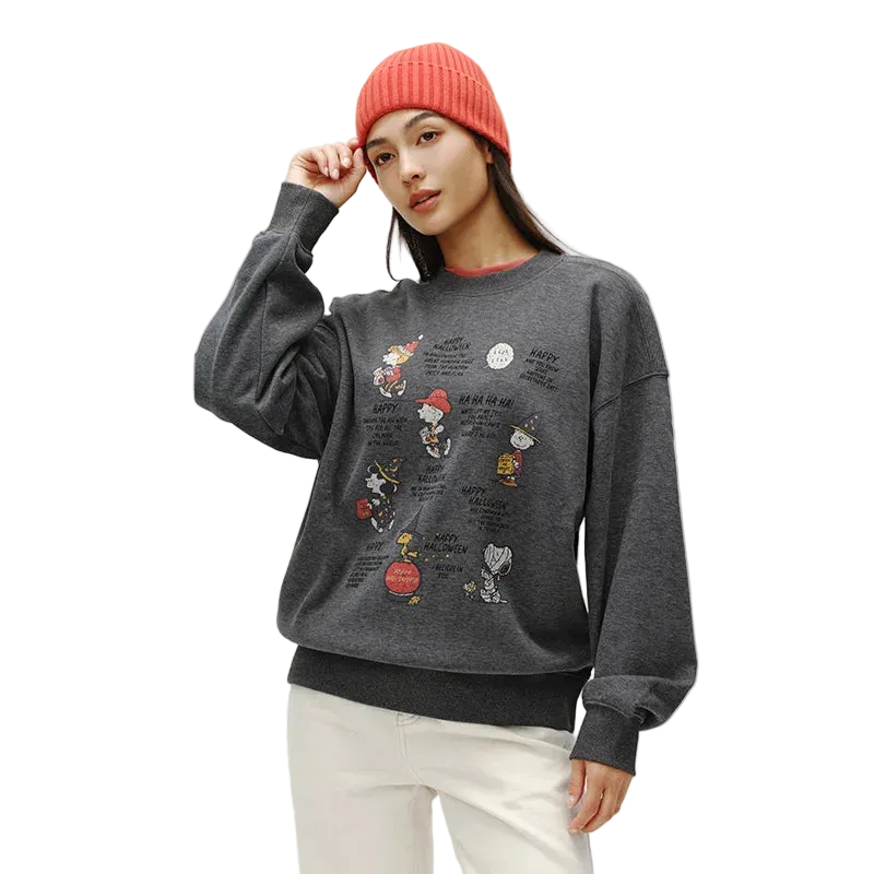 Person wearing a gray sweatshirt with cartoon character designs on a plain background