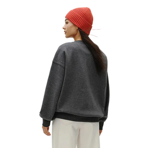 Person wearing a gray sweatshirt and red beanie on a plain background