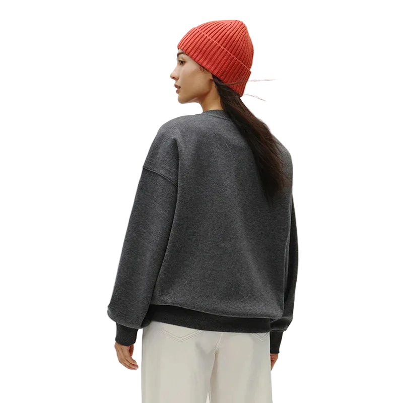Person wearing a gray sweatshirt and red beanie on a plain background