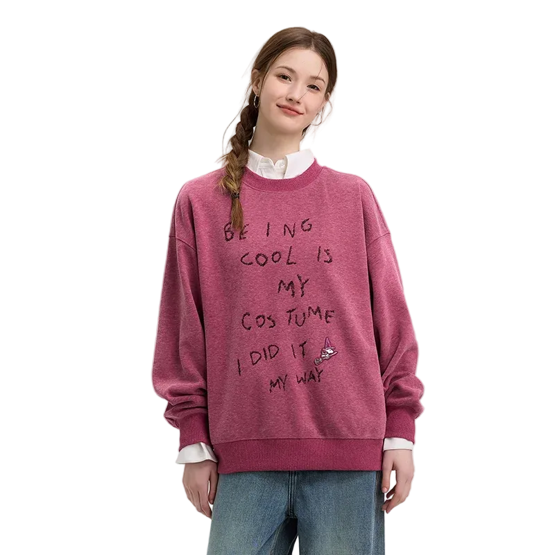 Person wearing a pink sweatshirt with text on a plain background