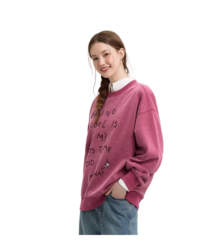 Person wearing a maroon sweatshirt with text on a plain background