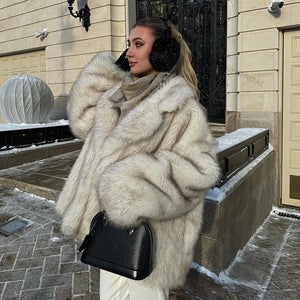 Woman in a fur coat standing on a snowy street