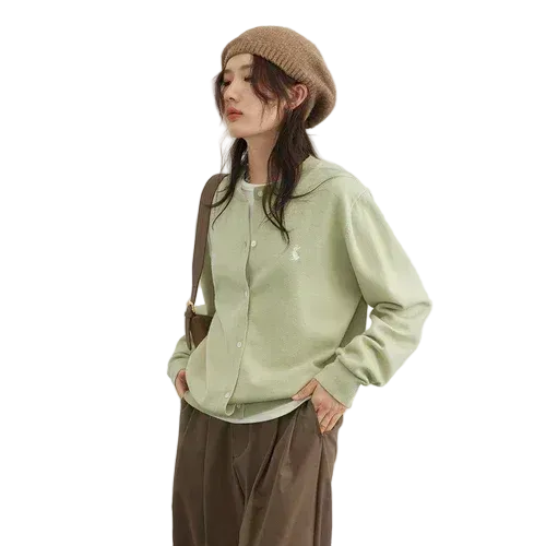 Person wearing a light green shirt and brown pants with a beige beanie on a white background